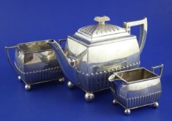 A Victorian three piece silver tea set, of demi-fluted rectangular form, with ball feet, Horace