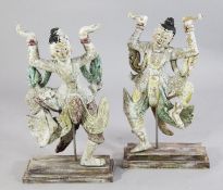 A pair of Burmese carved and painted wood dancing figures, each on a rectangular stepped base, 2ft