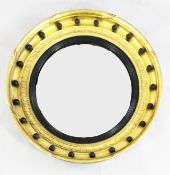 A Regency circular gilt convex wall mirror, with ebonised reeded slip, the frame with applied