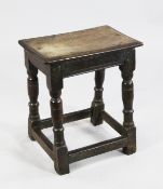 A 17th / 18th century oak joynt stool, with rectangular peg top, on ring turned baluster legs