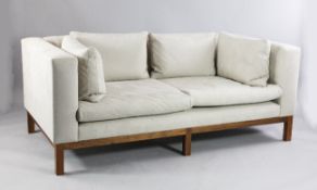 A De La Espada two seat settee, with walnut frame, upholstered in pale beige Alcantara