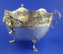 An Edwardian parcel gilt silver rose bowl, with triple scroll handles, pierced rim and pad feet,