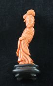 A Chinese coral figure of a female beauty, wearing long flowing robes, 8.3cm. excl. wood stand