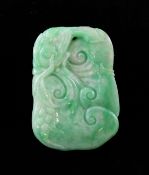 A Chinese green jadeite plaque, 19th century, carved in relief with a bird grasping fruiting