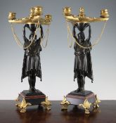 A pair of French patinated bronze and ormolu Empire style candelabra, with central beaded classical