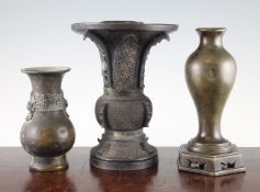 Three Chinese / Japanese bronze vases, 18th / 19th century, the first a baluster vase with integral