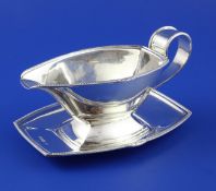 A 1930`s Art Deco silver sauce boat on stand by Mappin & Webb, the gadrooned border with fan