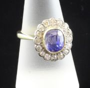 An 18ct gold, sapphire and diamond cluster ring, the central oval stone bordered by sixteen
