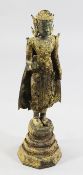 A large Thai gilt bronze standing figure of Buddha, on a stepped octagonal pedestal, 75cm.