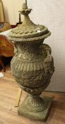 A large reconstituted stone two handled garden urn and cover, with gadrooned ovoid body and floral