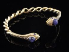 A gold, cabochon sapphire and diamond set spiral twist bangle, with snake head terminals.
