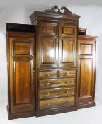 A Gillow & Co late Victorian rosewood breakfront wardrobe, the central broken swan neck pediment