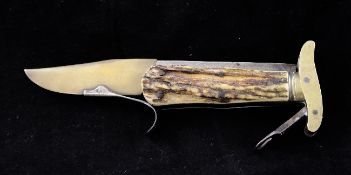 A 20th century folding bowie knife, with horn grips and hinged locking lever marked MI Ltd,