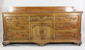 A George III mahogany dresser base, with reeded quarter pillar sides, fitted an arrangement of