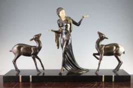 A French Art Deco bronze spelter and ivorine group of a woman with two deer, signed Menneville,