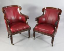 A near pair of early 19th century inlaid mahogany library armchairs, with stiff leaf carved