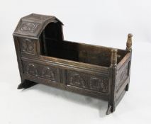 An 18th century and later carved oak cradle, with lunette and lozenge panels, on rocker supports,