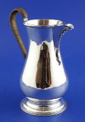 A George III silver ale jug, of baluster form, with beaded spout and rattan bound handle, Hester