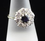 An 18ct gold and platinum sapphire and diamond cluster ring, with central sapphire bordered by nine