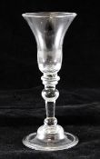 A balustroid wine glass, C.1730, the bell shaped bowl set on a triple and baluster knopped stem, on
