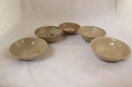 Three Chinese Yue ware bowls and two Sukhothai bowls, 11th / 15th century, two of the Yue ware