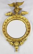 A 19th century gilt convex wall mirror, with eagle surmount and applied ball decoration, 3ft 6in.