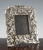 An Art Nouveau style silvered pewter photograph frame, embossed with winged cherubs and flowing