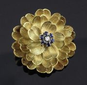 A sapphire and diamond set 18ct gold flowerhead brooch, 1.25in.