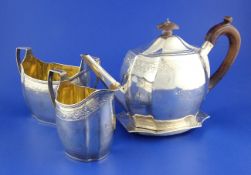 A George III silver three piece tea set and teapot stand by Robert & David Hennell, of oval form
