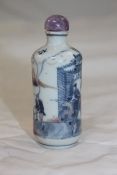 A Chinese underglaze blue and copper red snuff bottle, 1830-1900, painted with a horseman by a city