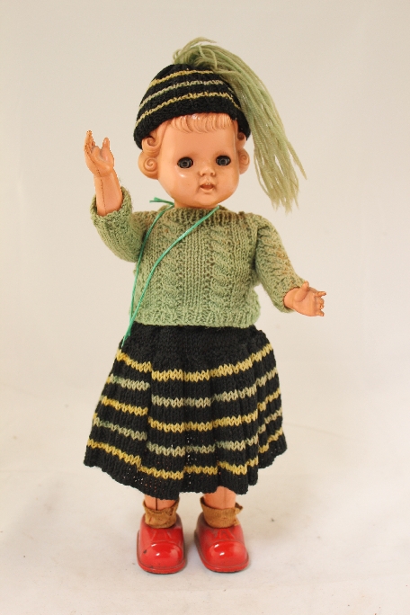 A 1950`s Masudaya tinplate and celluloid clockwork walking doll, with rollers to the base of feet,