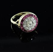 An 18ct gold, ruby and diamond target ring, set with old cut diamonds and shaped cut ruby border (