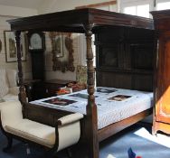 A carved oak four poster bed, in the 17th century style, with panelled headboard and turned end