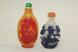 Two Chinese overlaid glass snuff bottles, 1750-1880, the first carved in red overlay with a bat and