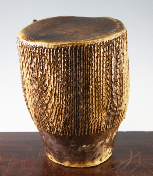 A late 19th / early 20th century African skin and hide hand drum, of typical form, 12in.