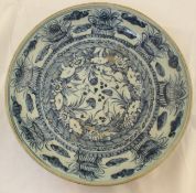 A Ming Chinese blue and white dish, 15th century, the cavetto with eight vegetal swags, the centre