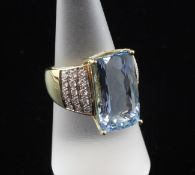 An 18ct gold aquamarine and diamond set dress ring, with pave diamond set shoulders and fancy cut