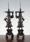 A pair of Chinese late Ming pricket figural candlesticks, cast in the form of `foreigners`