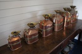 A collection of six graduated copper and brass check pump measures, 5 gallons to ½ gallon, engraved