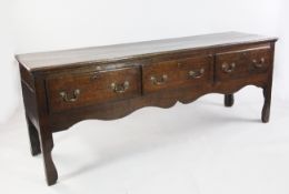 An early 18th century oak dresser base, fitted three drawers with shaped frieze and legs, W.6ft