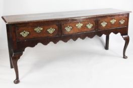 A mid 18th century oak and cross banded mahogany low dresser, with three drawers above a wavy