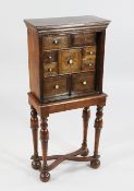 A small oak and walnut chest on stand, fitted with nine boxwood and ebony inlaid drawers with ivory