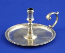 A George III silver taper chamberstick, with flying scroll handle and beaded rim, George Wintle,