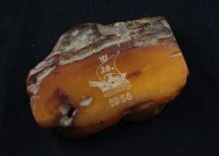 A free form block of unpolished amber, with dated inscription, weight 86 grams, 3.25in approx.
