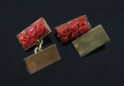 A pair of gold and carved coral cufflinks, of rectangular form, the coral panels carved with