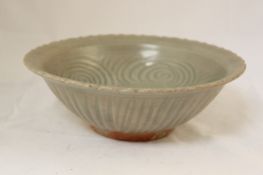 Two Thai Sawankhalok celadon bowls, 14th / 15th century, the first with petalled rim with an
