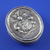 A silver oval box in the 17th century style, with reeded borders, the lid embossed with ornate