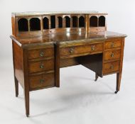 A late Victorian satinwood and rosewood crossbanded kneehole writing desk, the raised back with