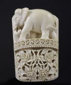 An early 20th century relief carved ivory panel, depicting a standing elephant and entwined flowers,
