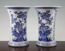 A pair of Chinese blue and white cylindrical vases, Kangxi period, with trumpet necks, painted to